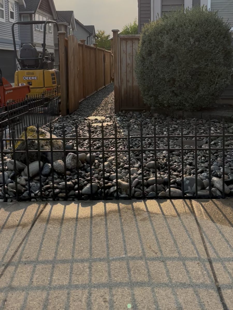 The same yard filled with river rock and feature boulders